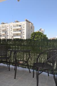 a couple of chairs sitting next to a fence at Двуспальная квартира возле дасуди in Limassol