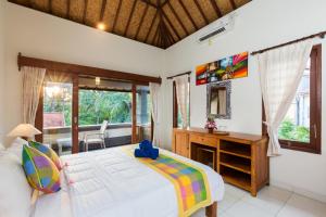 a bedroom with a bed and a desk and a window at Wenara Bali Bungalows in Ubud +37 photos