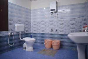 Un baño azul con inodoro y lavabo. en Agasthya Homestay - With Kitchenette, en Madikeri 25 fotos más