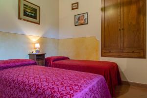 サン・ジミニャーノにあるAzienda Agricola Fornacelleのベッド2台とキャビネット付きのホテルルームです。