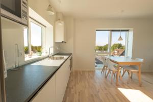 a kitchen with a table and a dining room at Aalborg Hotel Apartments in Aalborg