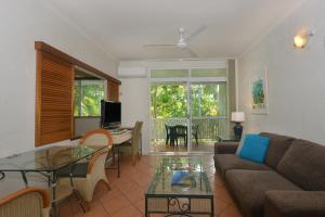 a living room with a couch and a table at Seascape Holidays - Coral Apartments in Port Douglas