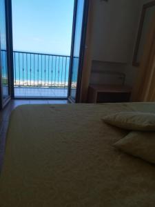 1 dormitorio con 1 cama y vistas al océano en Affittacamere Bellavista, en Agropoli