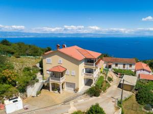 an aerial view of a house with the ocean in the background at Apartman EN in Mošćenička Draga