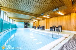 a large swimming pool with chairs in a building at Hotel Sorsanpesä in Seinäjoki