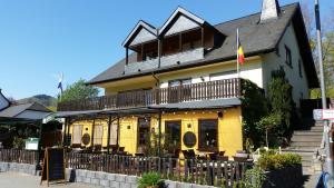 een geel gebouw met een balkon erboven bij Hotel Zur Brücke in Senheim