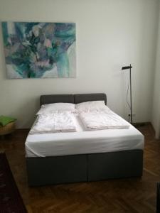 ウィーンにあるJugendstil Garconniereの壁に絵画が描かれたベッドルームのベッド1台