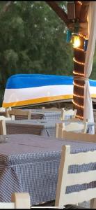 a blue and white train on tracks with tables and chairs at Oriental Bay in Palaiochora