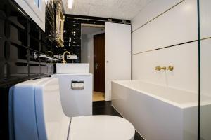 Baño blanco con aseo y lavamanos en Hotel Montmar en Roses