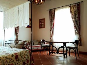 una camera con letto, tavolo e sedie di Fattoria di Marena a Bibbiena