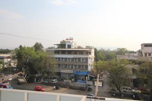 un gran edificio blanco con un estacionamiento delante de él en Hotel Girnar, en Aurangabad