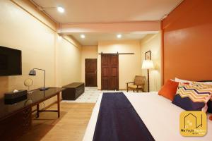a bedroom with a bed and a desk and a television at Na Vayla PaPlern in Bangkok +46 photos