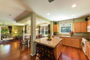 a large kitchen with wooden cabinets and a dining room at Nihilani 25C in Princeville