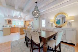 a kitchen and dining room with a wooden table and chairs at #OB Pool House in Oak Bluffs