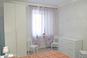 1 dormitorio con 1 cama, vestidor y ventana en Struttura Turistica Villa Calamita en Capoliveri