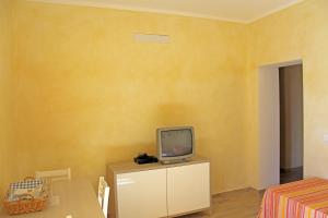 a small tv sitting on a dresser in a room at Struttura Turistica Villa Calamita in Capoliveri