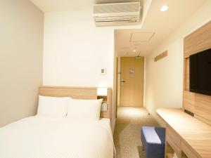 a hotel room with a bed and a tv at Sotetsu Fresa Inn Tokyo Kinshicho in Tokyo