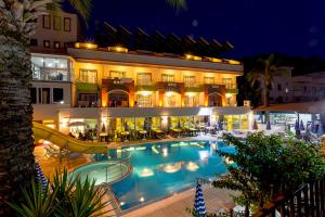 a large hotel with a swimming pool at night at Rich Melissa Hotel in Kemer
