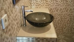 ein Waschbecken im Bad mit einer schwarzen Schüssel auf der Theke in der Unterkunft Bali Sari Homestay in Amed