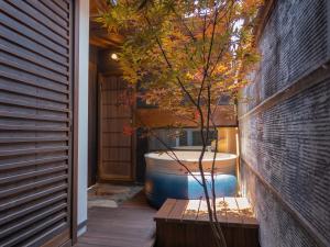 bañera en un porche con un árbol en Kiraku Kyoto Gion, en Kioto