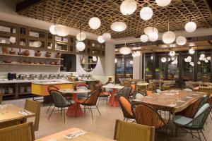 a restaurant with tables and chairs and lights at ARTOTEL Yogyakarta in Yogyakarta