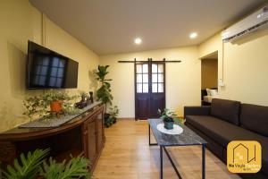 a living room with a couch and a tv at Na Vayla PaPlern in Bangkok