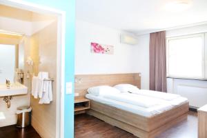 una camera d'albergo con letto e bagno di Hotel - Restaurant Valley Rose a Vienna