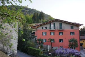 une maison sur une colline avec des fleurs violettes devant elle dans l'établissement Bellagio Bed & Breakfast, à Bellagio