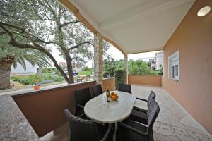 a patio with a table and chairs and a window at Apartmani Rudi in Vir