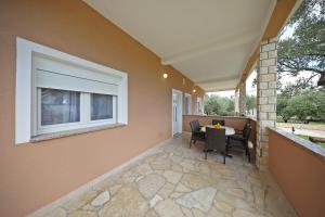 a patio with a table and chairs and a window at Apartmani Rudi in Vir +41 photos