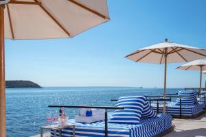 - un groupe de chaises et de parasols à côté de l'eau dans l'établissement Meliá Calviá Beach, à Magaluf