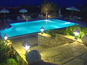 ein Schwimmbad in der Nacht mit Lichtern in der Unterkunft Anatoli Labreon in Agia Marina