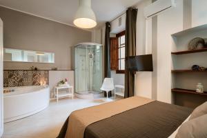 a bedroom with a bed and a tub and a shower at Stampace Apartments in Cagliari