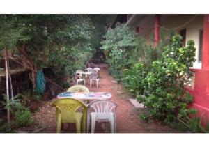um pátio com mesas e cadeiras num jardim em Private rooms near Chapora fort em Vagator