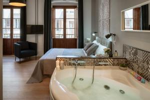 a bathroom with a bath tub next to a bed at Stampace Apartments in Cagliari