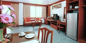 eine Küche und ein Wohnzimmer mit einem Kühlschrank und einem Tisch in der Unterkunft Hua Hin Loft in Hua Hin
