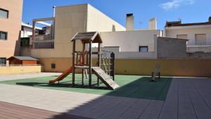 um parque infantil com um escorrega no topo de um edifício em SHG APARTAMENTOS MONT-ROIG em Mont-roig del Camp