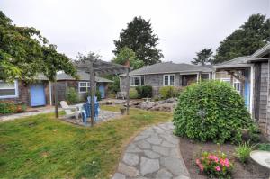 a house with a yard with a stone pathway at Hidden Villa Cottages in Cannon Beach