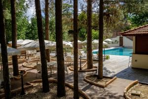 a resort with a pool and tables and umbrellas at Platres Valley Houses in Platres