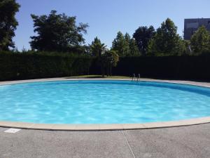a large swimming pool with blue water at L Oasis studio proche hôpital et aéroport Piscine Parking &Netflix in Toulouse