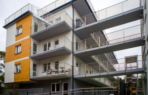 an apartment building with balconies on the side of it at Apartamenty Piaskowe Rowy in Rowy