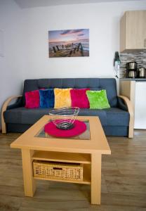 a coffee table in a living room with a blue couch at Apartamenty Piaskowe Rowy in Rowy +13 photos