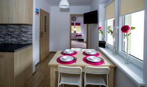 a kitchen with a table and chairs in a room at Apartamenty Piaskowe Rowy in Rowy