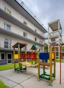 a group of playground equipment in front of a building at Apartamenty Piaskowe Rowy in Rowy
