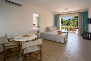 ein Wohnzimmer mit einem Bett, einem Tisch und Stühlen in der Unterkunft Avanti Holiday Village in Paphos City