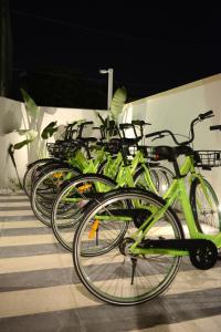 una fila de motos verdes estacionadas junto a una pared en Riva 33, en Porto Cesareo