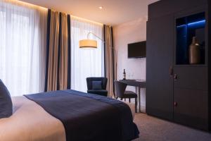 una camera d'albergo con letto e scrivania di Hôtel La Bourdonnais by Inwood Hotels a Parigi