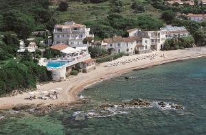 a beach with a group of people laying on the beach at Hotel Le Maquis in Porticcio