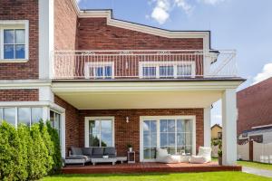 a brick house with a balcony on top of it at Smėlynas Klaipėda Lake House in Klaipėda