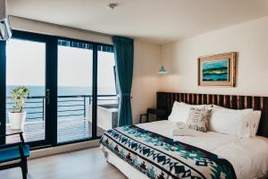 Schlafzimmer mit einem Bett und Meerblick in der Unterkunft Chuanfanrock Haku Beach Days Inn in Eluan